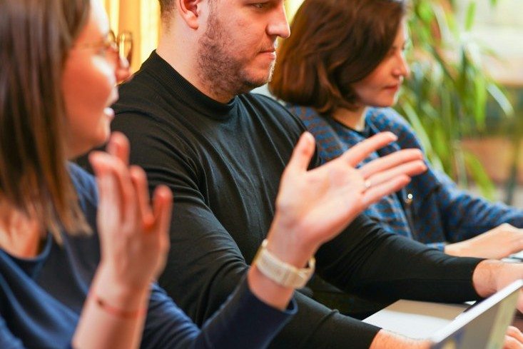 Metodología Smarketing: equipo conversando en una mesa de trabajo para coordinar marketing y ventas