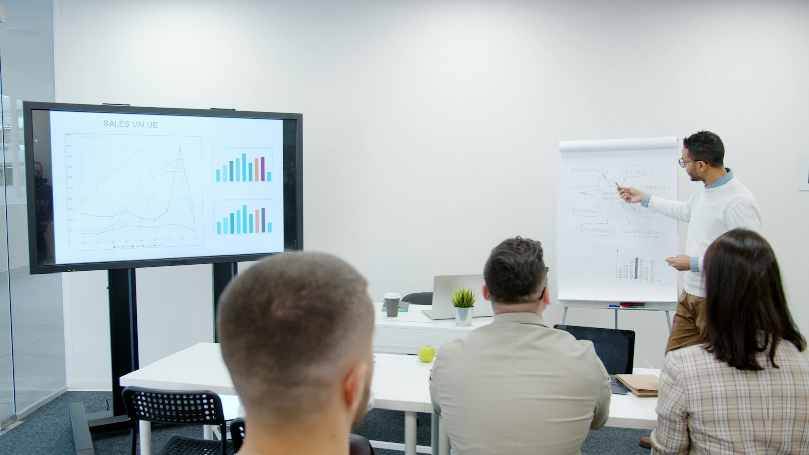 Qué hace un consultor de marketing: especialista presentando resultados y gráficas a un equipo de negocios en una sala de juntas